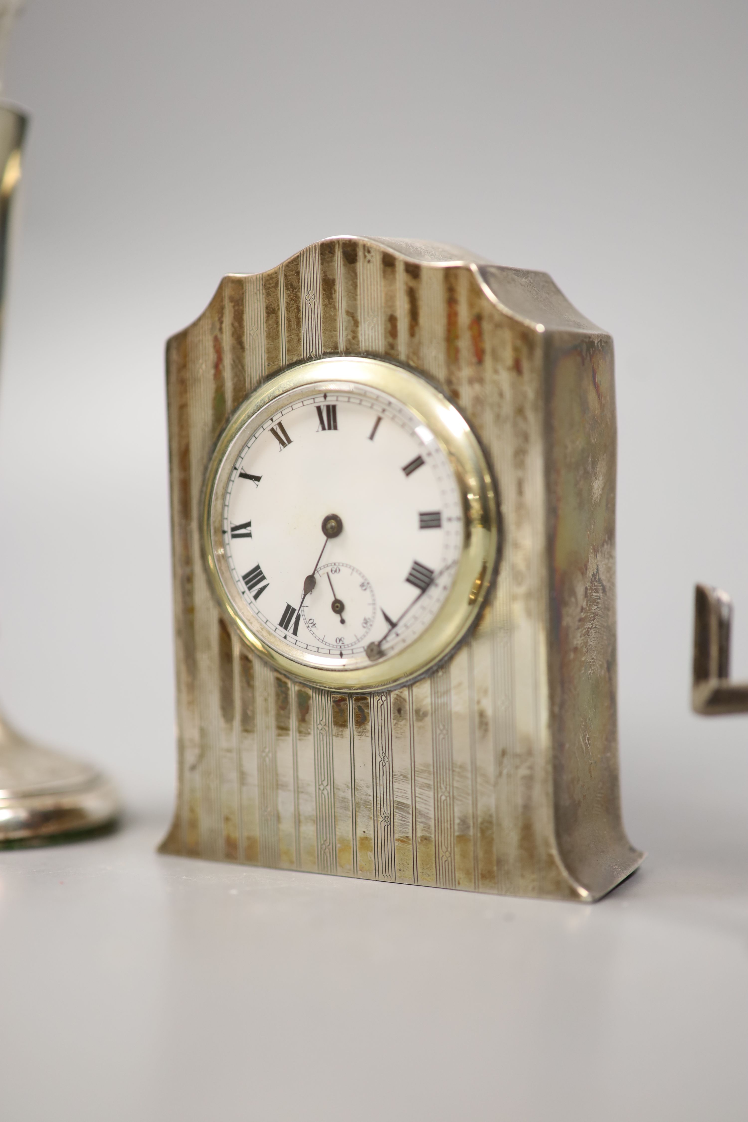 A George V silver cased bedside timepiece, a silver and ivory perpetual calendar and a pair of silver and ivory knife rests